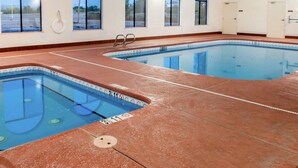 Une piscine intérieure à l’eau claire, dotée de couloirs délimités et d’un poste de surveillance pour le sauveteur.