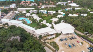An aerial view of a resort with multiple buildings, a swimming pool, and a parking area. - Henry Morgan Resort - All Inclusive (Roatan)