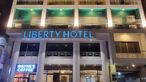 The Liberty Hotel with multiple balconies, a prominent sign, and a Wayne's Coffee sign. - Liberty Hotel Saigon Parkview (Ho Chi Minh City)