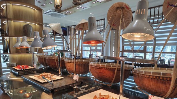 A buffet area with various food items, baskets, and modern lighting fixtures. - Liberty Hotel Saigon Parkview (Ho Chi Minh City)