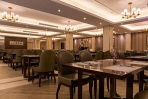 A spacious hotel dining area with multiple tables and chairs, chandeliers, and a modern interior design. - Metropolo Shanghai Minhang Hotel (Shanghai)