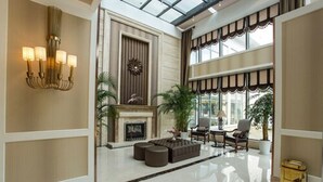A spacious lobby with a fireplace, seating area, and large windows. - Metropolo Shanghai Minhang Hotel (Shanghai)