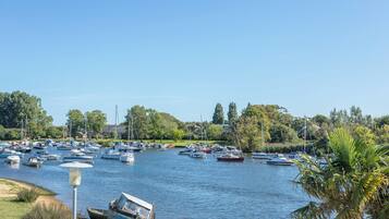 A marina with numerous boats docked, surrounded by greenery and trees.