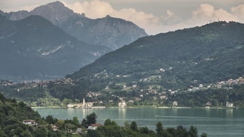 Eine Stadt am Seeufer mit einer markanten Kirche auf einem Hügel, umgeben von Bergen und dichtem Grün.