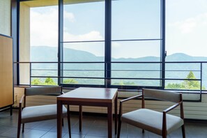 A room with a large window offering a mountain view, a wooden table, and two chairs. - Hyatt Regency Hakone Resort and Spa (Hakone)