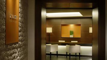 Welcome to izumi spa onsen, where guests can check in at the central reception desk, surrounded by a unique textured pattern and the hotel's name prominently displayed.