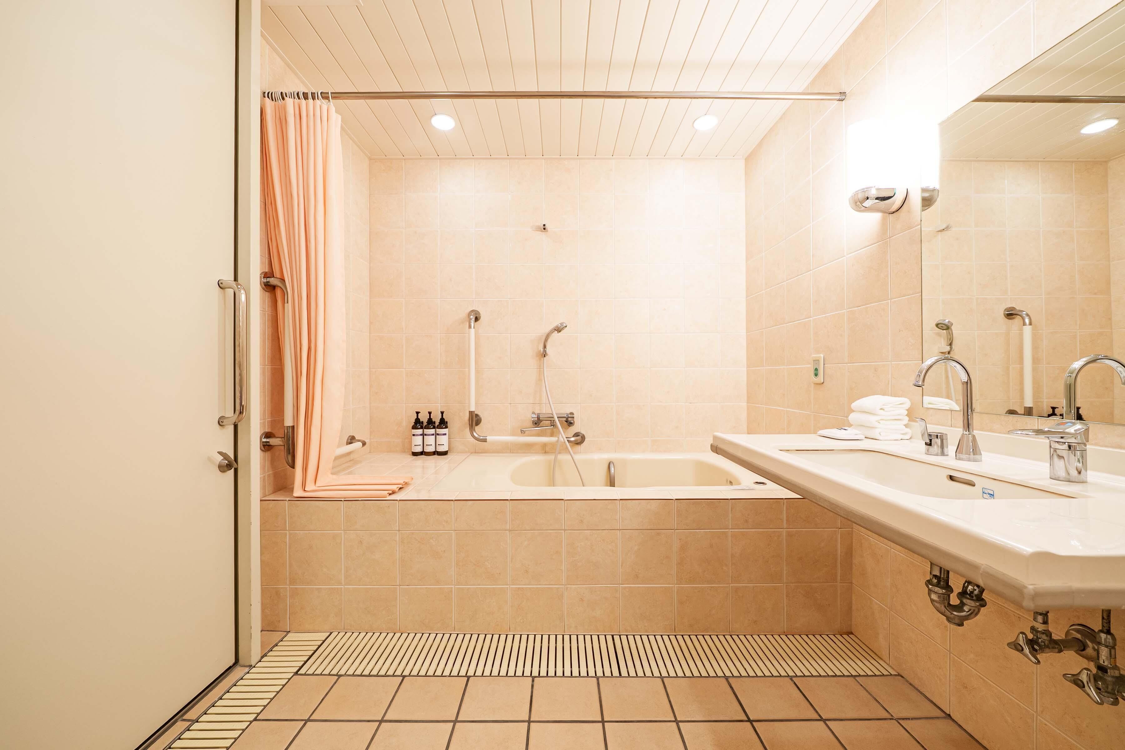 A modern bathroom with a bathtub, a shower, and a sink.