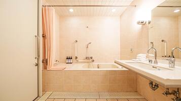 Een moderne badkamer met een bad, douche en wastafel.