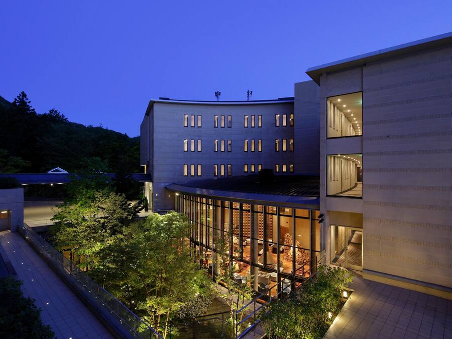A modern building with multiple floors, large windows, and a glass facade.