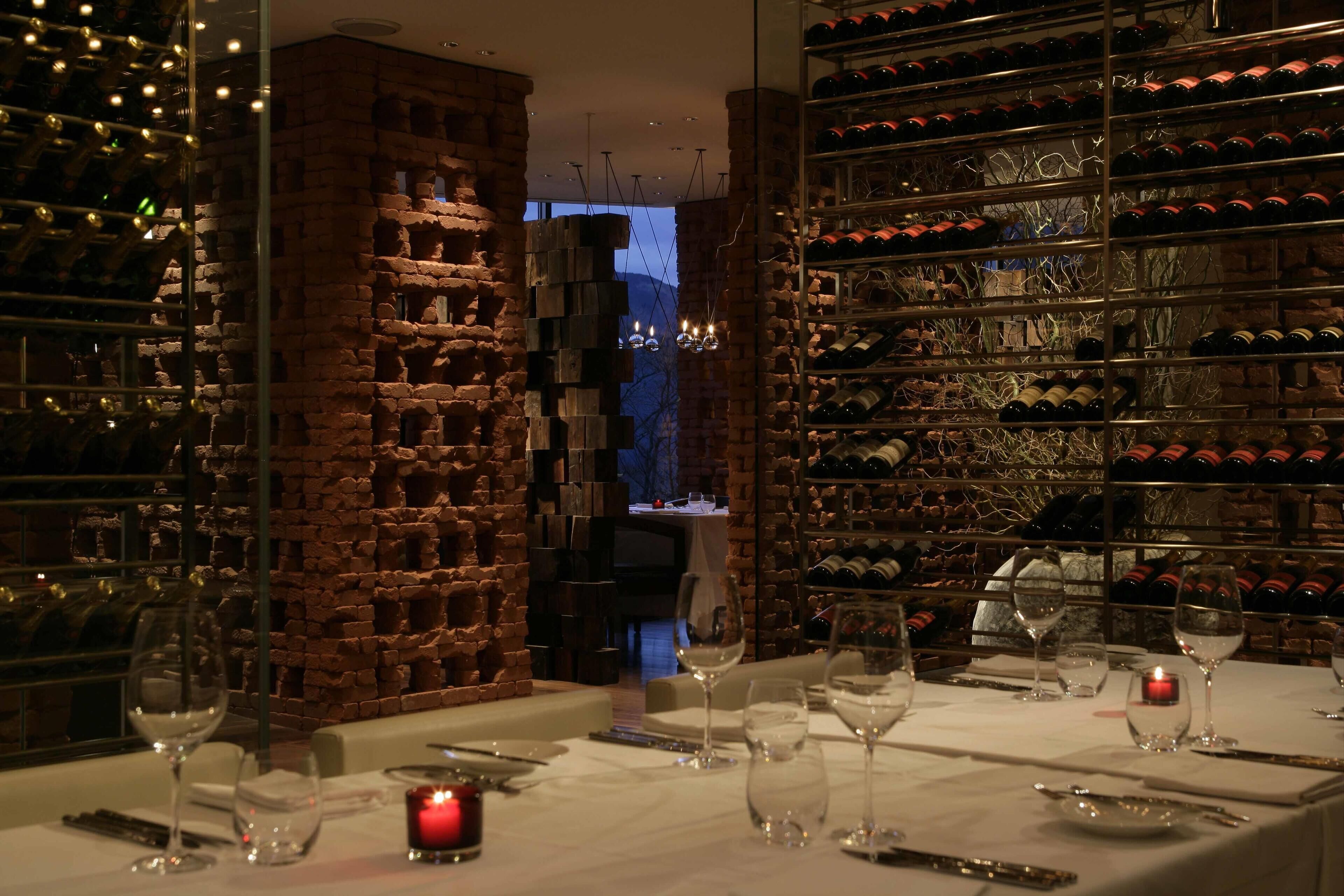 A restaurant with a brick wall and wine racks.
