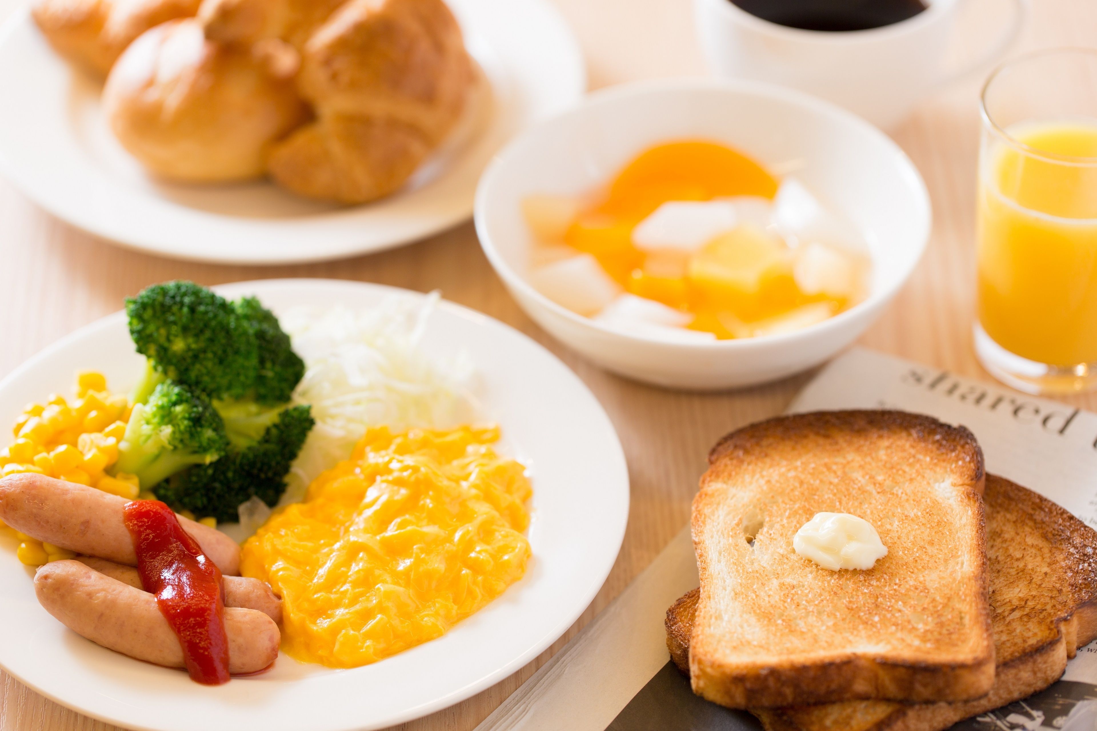 Un piatto per la colazione con uova strapazzate, salsiccia, broccoli e formaggio.