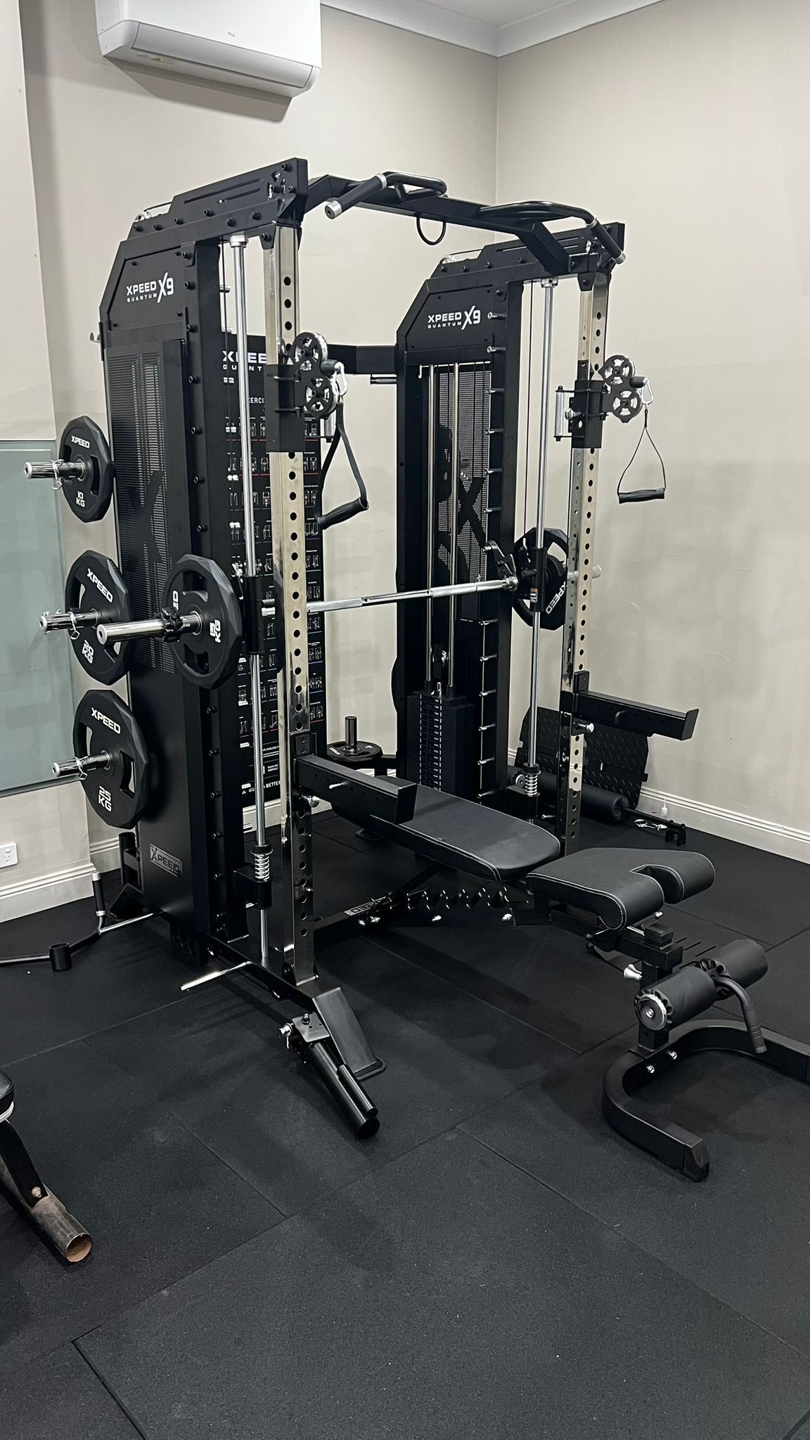 A weightlifting station with adjustable benches, a squat rack, and various weight plates.