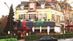 Un edificio de varios pisos con un restaurante en la planta baja.