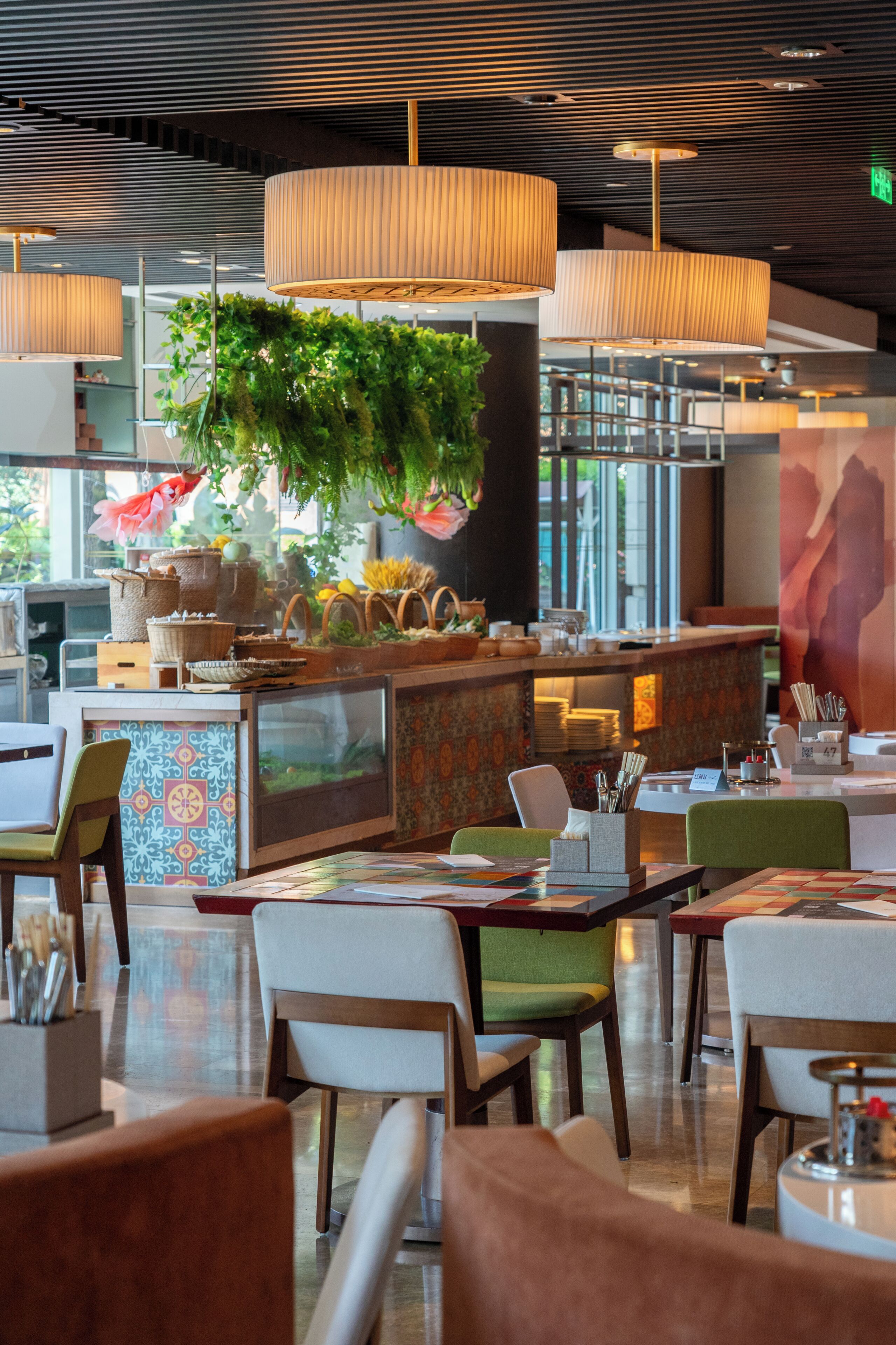 A restaurant interior with modern furnishings, a bar area, and a hanging plant.