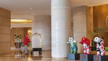 Experience the elegant lobby, featuring a striking cylindrical column and decorative animal statues, with a concierge service at your fingertips.