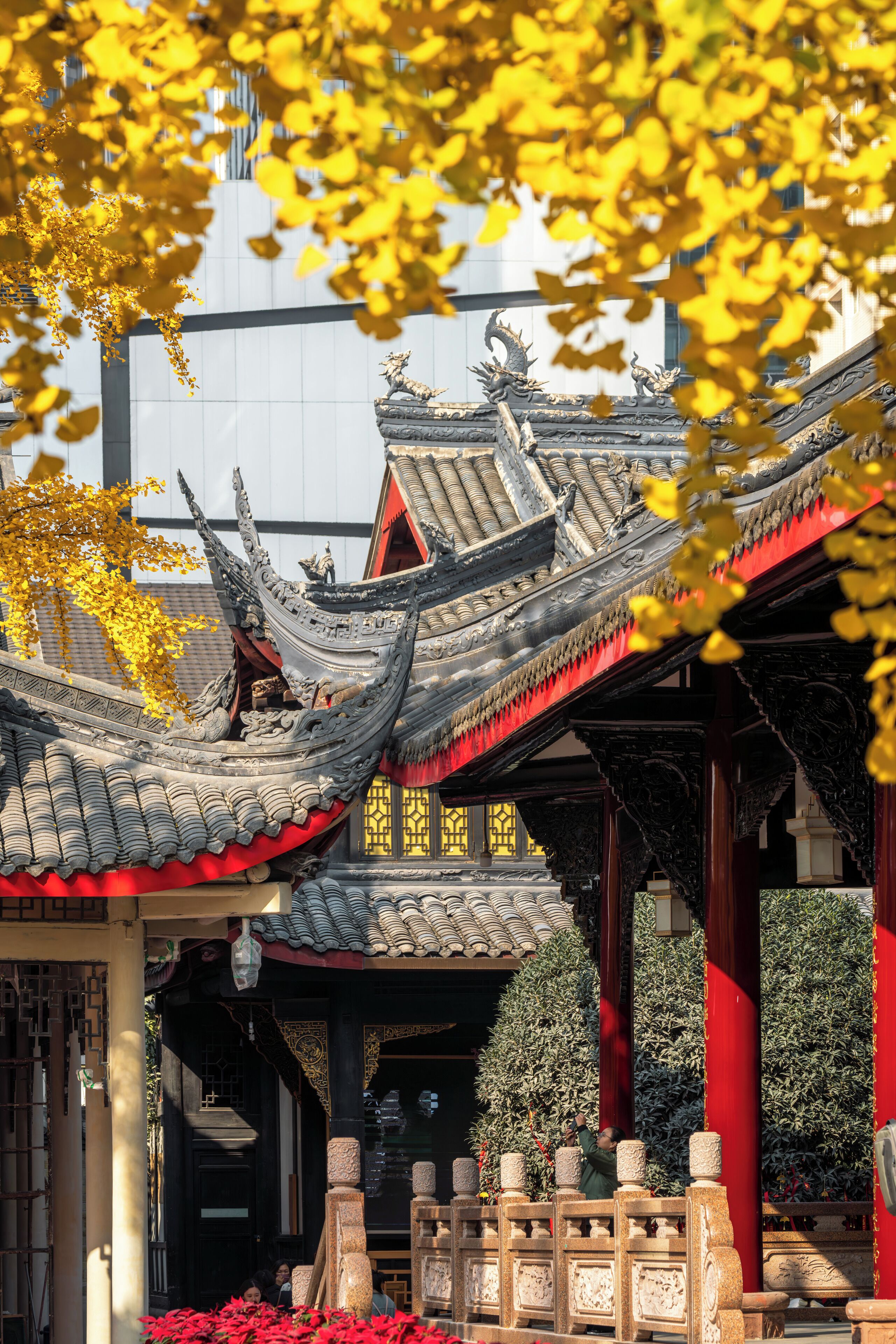 A traditional architectural structure with ornate roof designs and a red column.