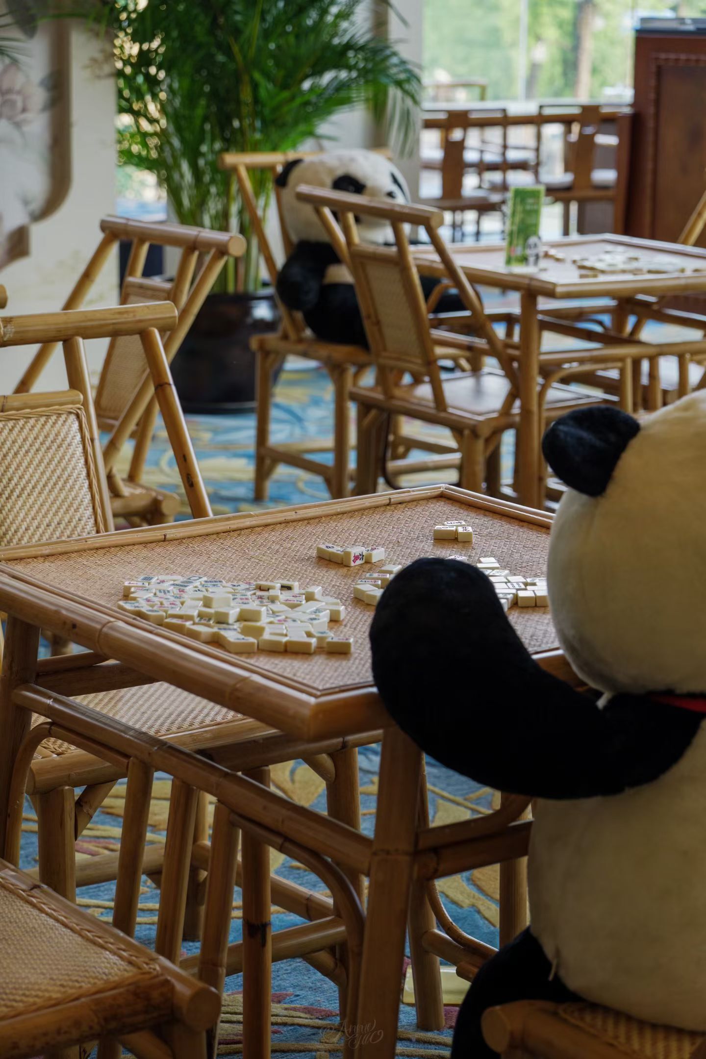 A room with bamboo furniture and a panda plush toy.