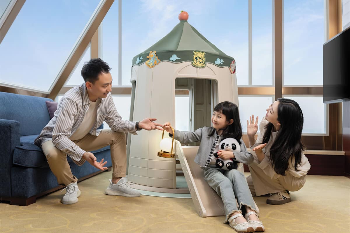 Una habitación con una casita de juegos, un sofá y una televisión.