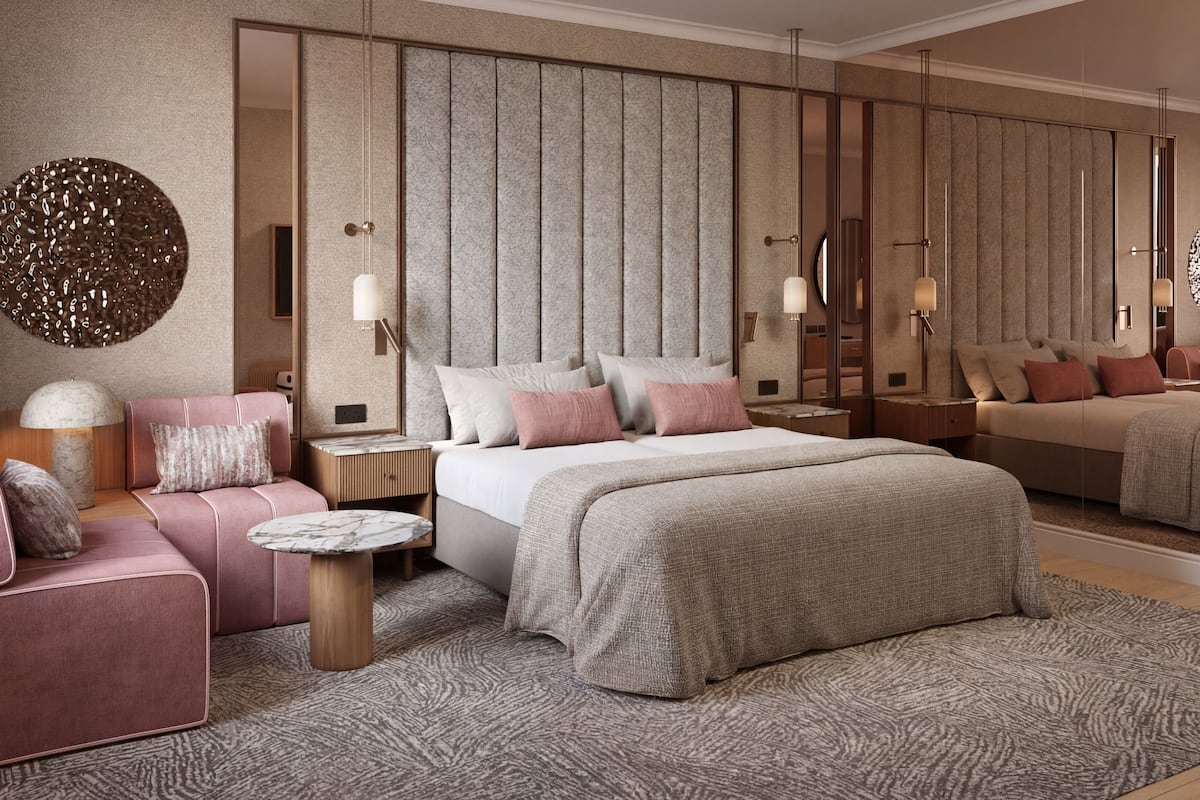 Ein modernes Schlafzimmer mit einem großen Bett, einer Couch, einem kleinen Tisch und einem Spiegel.