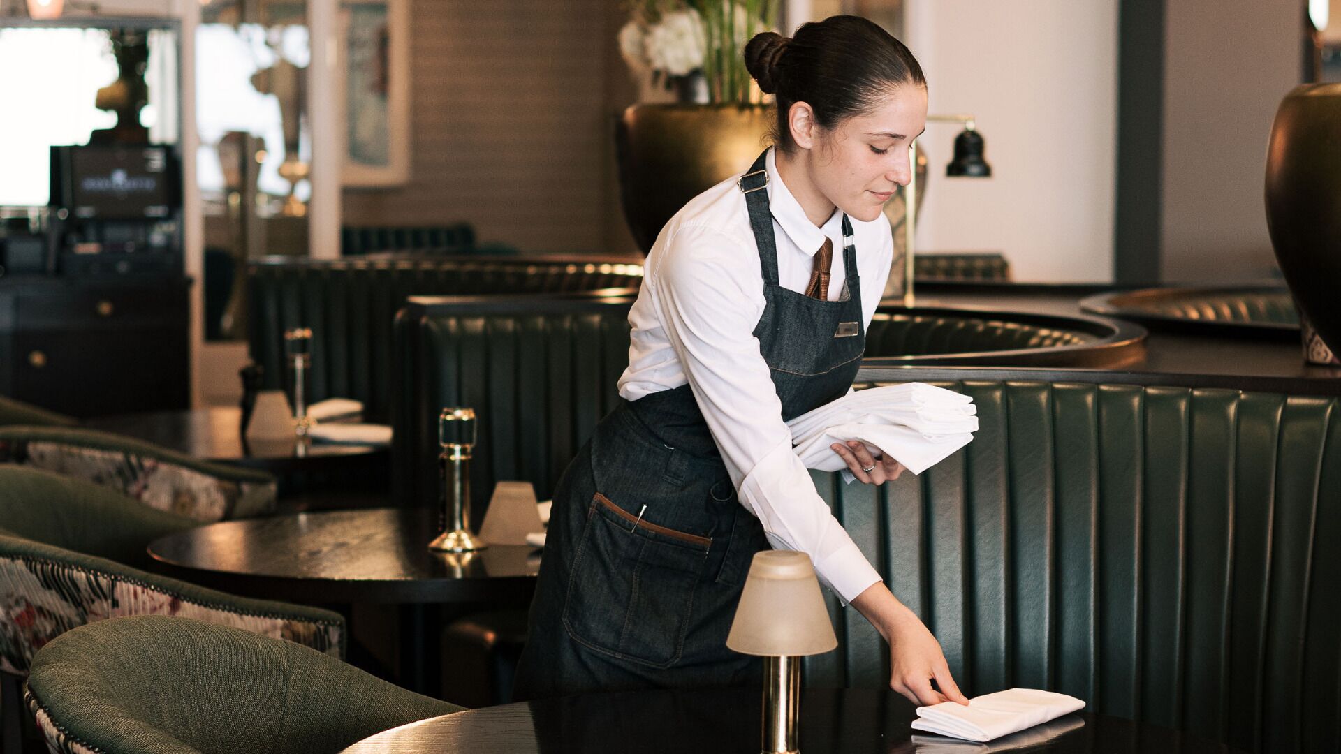 Un restaurante con una decoración moderna, que incluye asientos de cuero y una zona de bar.
