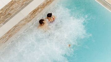 Ein Schwimmbecken mit zwei Personen im Wasser.