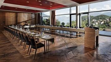 A conference room with a long table, chairs, and a podium.
