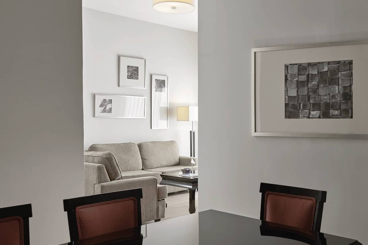 A modern living room with a sofa, coffee table, and framed artwork on the wall.