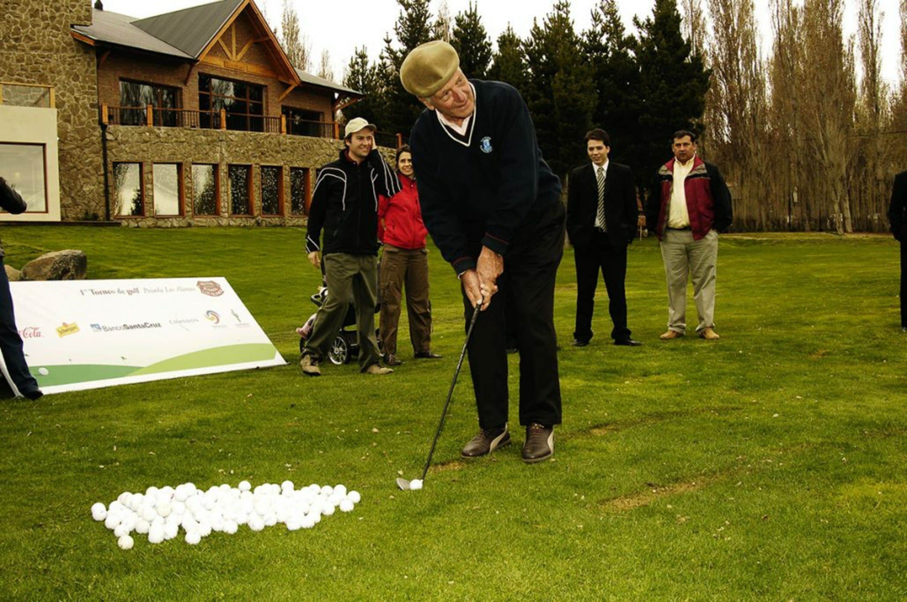 A golf course with a stone building in the background.