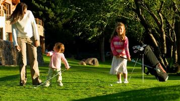 Un campo de golf con una familia jugando.