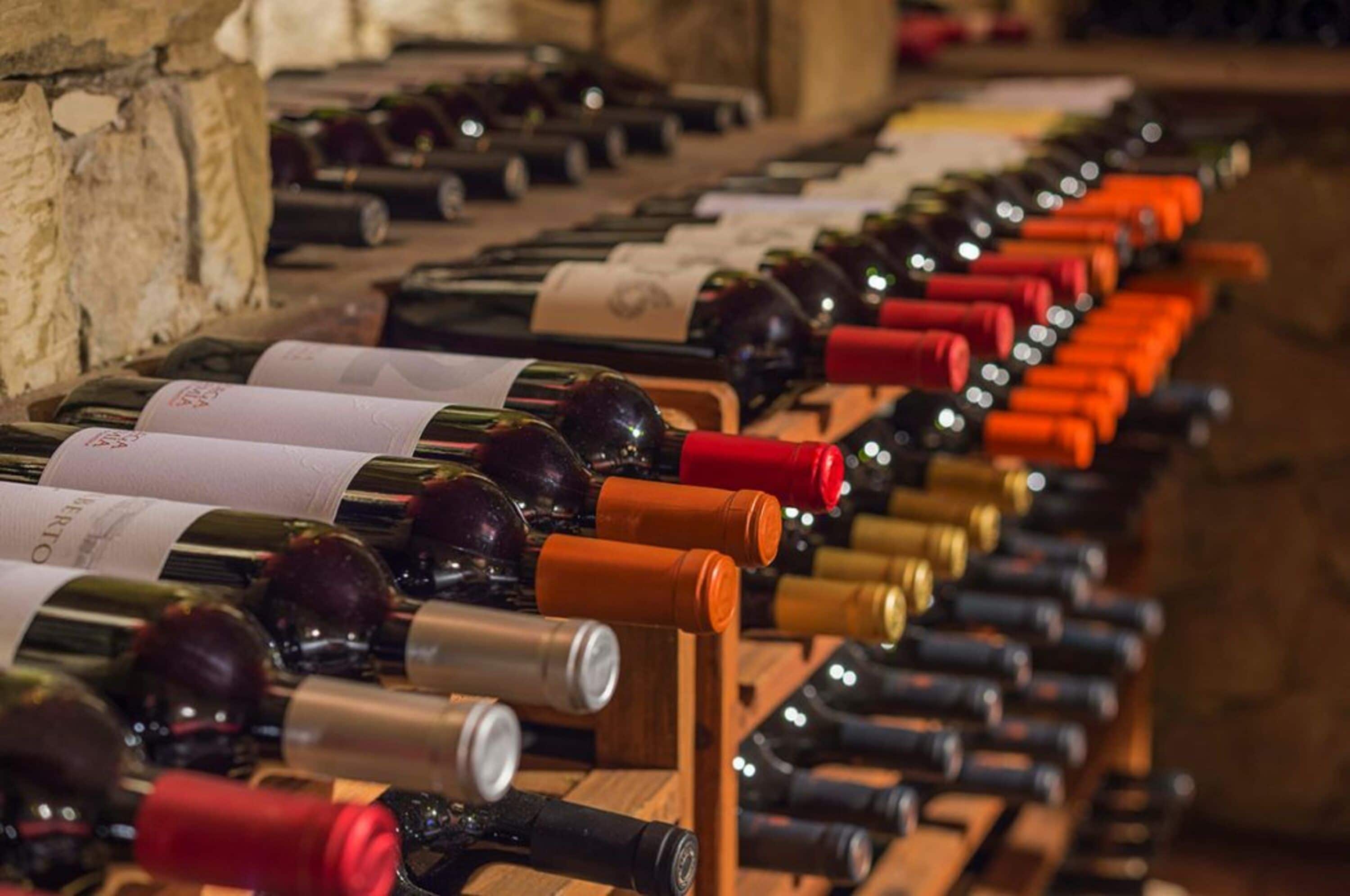 Une cave à vin avec des rangées de bouteilles de vin disposées sur des étagères en bois.