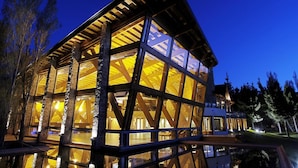 A modern building with large windows and a wooden exterior. - Hotel Posada Los Alamos (El Calafate)