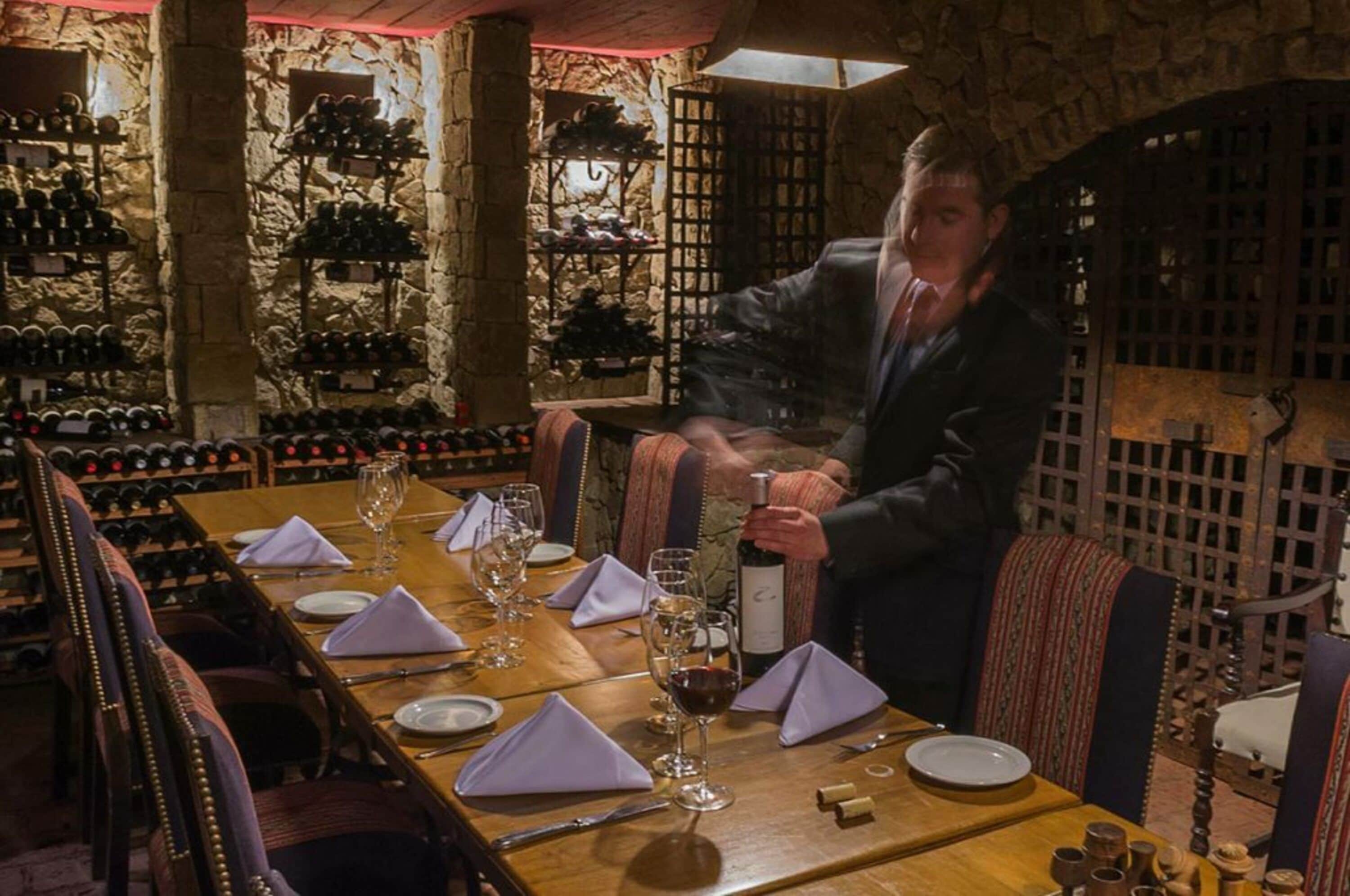A restaurant with a stone wall and wine racks.