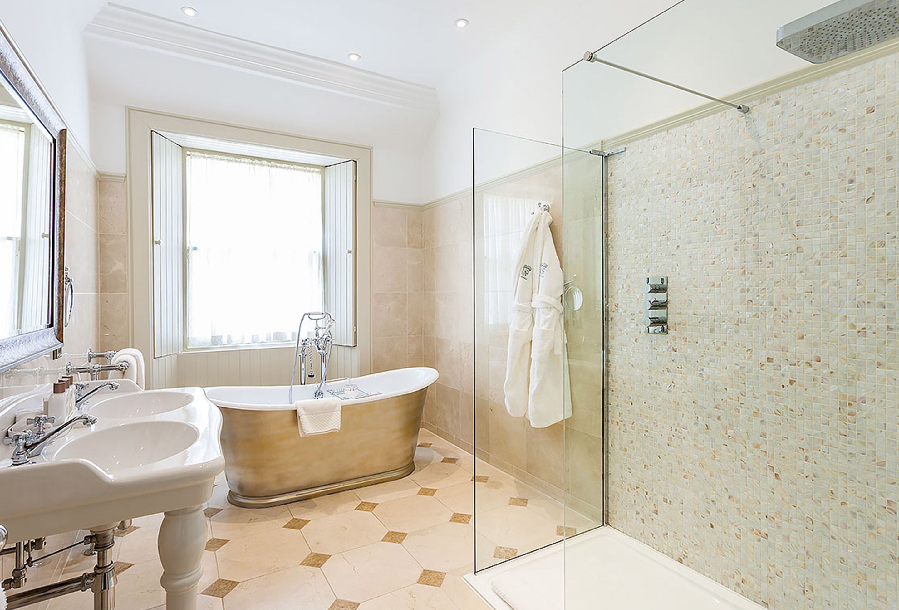 A modern bathroom with a freestanding bathtub, a glass-enclosed shower, and a large mirror.
