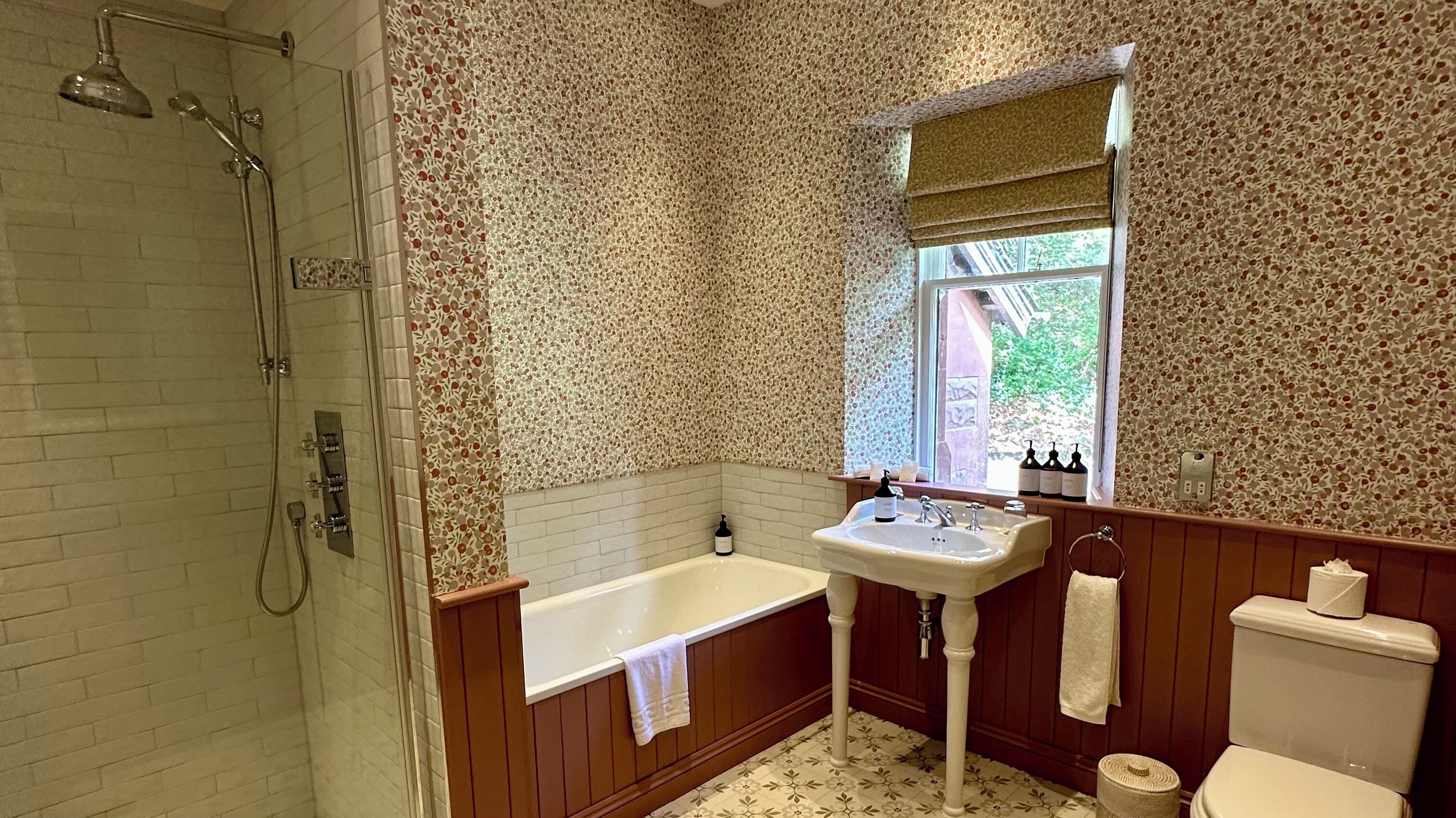 A bathroom with a shower, bathtub, sink, and toilet.