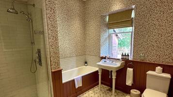 A bathroom with a shower, bathtub, sink, and toilet.