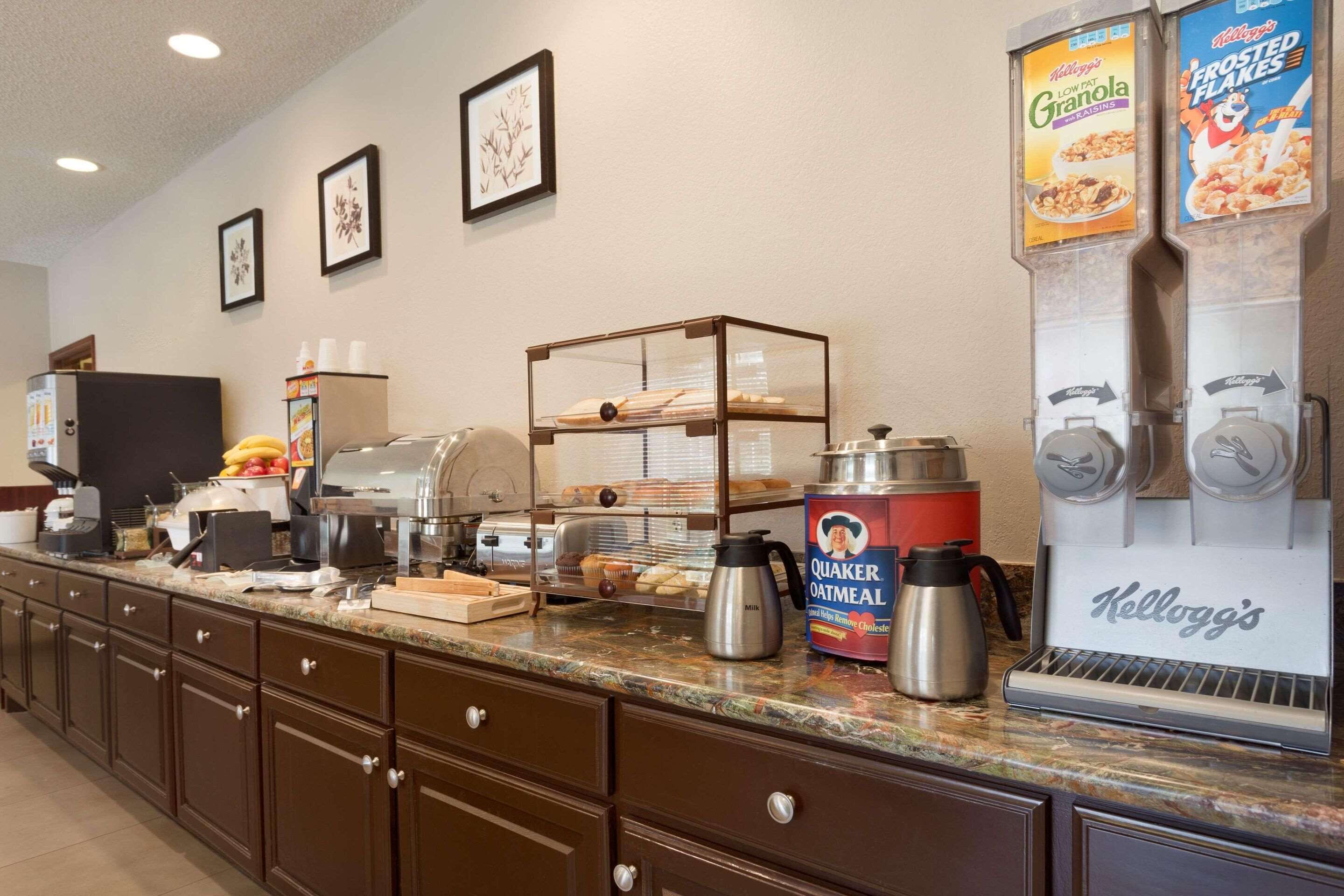 A breakfast bar with various food items and a coffee machine.