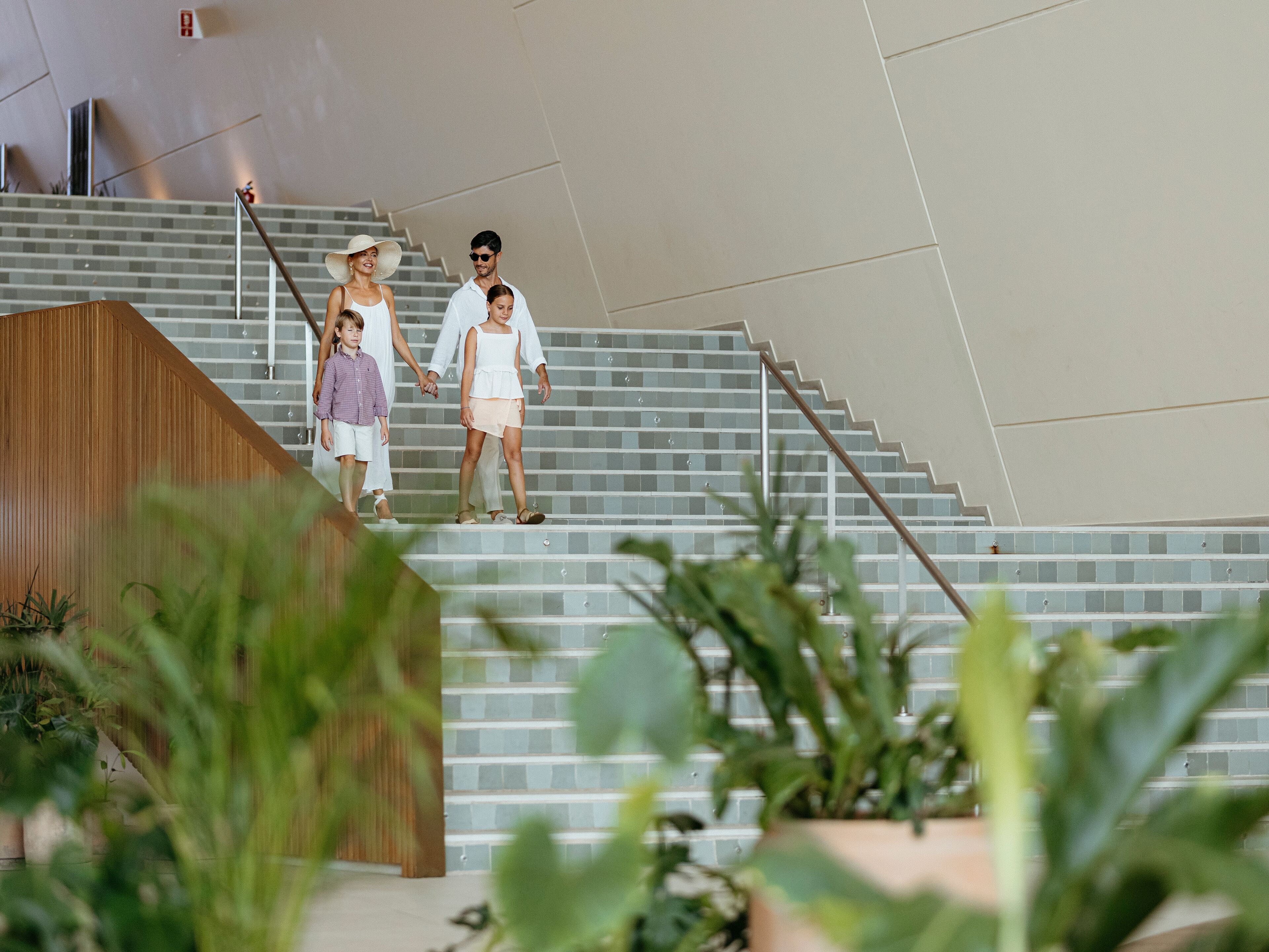 A staircase with a modern design, surrounded by indoor plants.