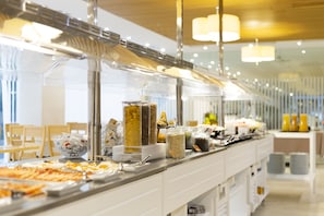 Uma mesa de buffet com diversos alimentos e acompanhamentos.