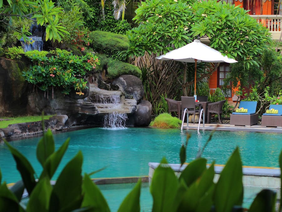 Een buitenzwembad, ligstoelen bij het zwembad