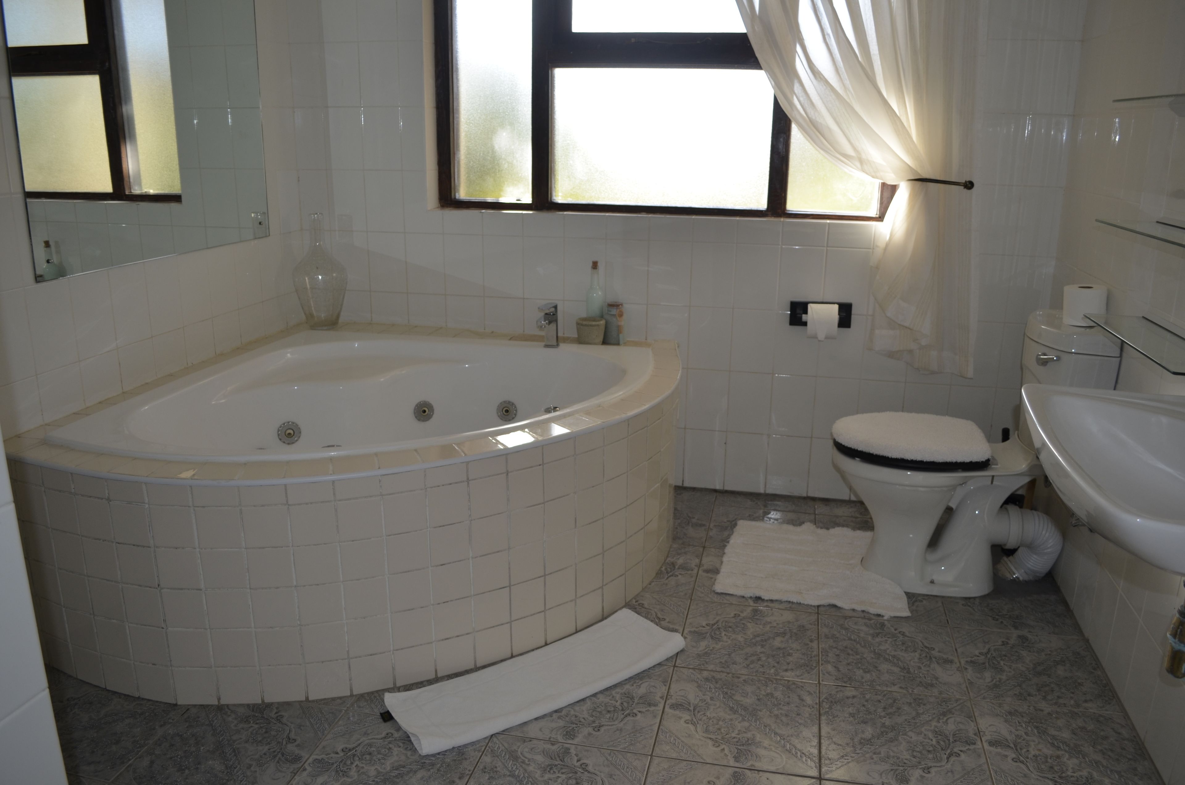 A bathroom with a large bathtub, toilet, and sink.