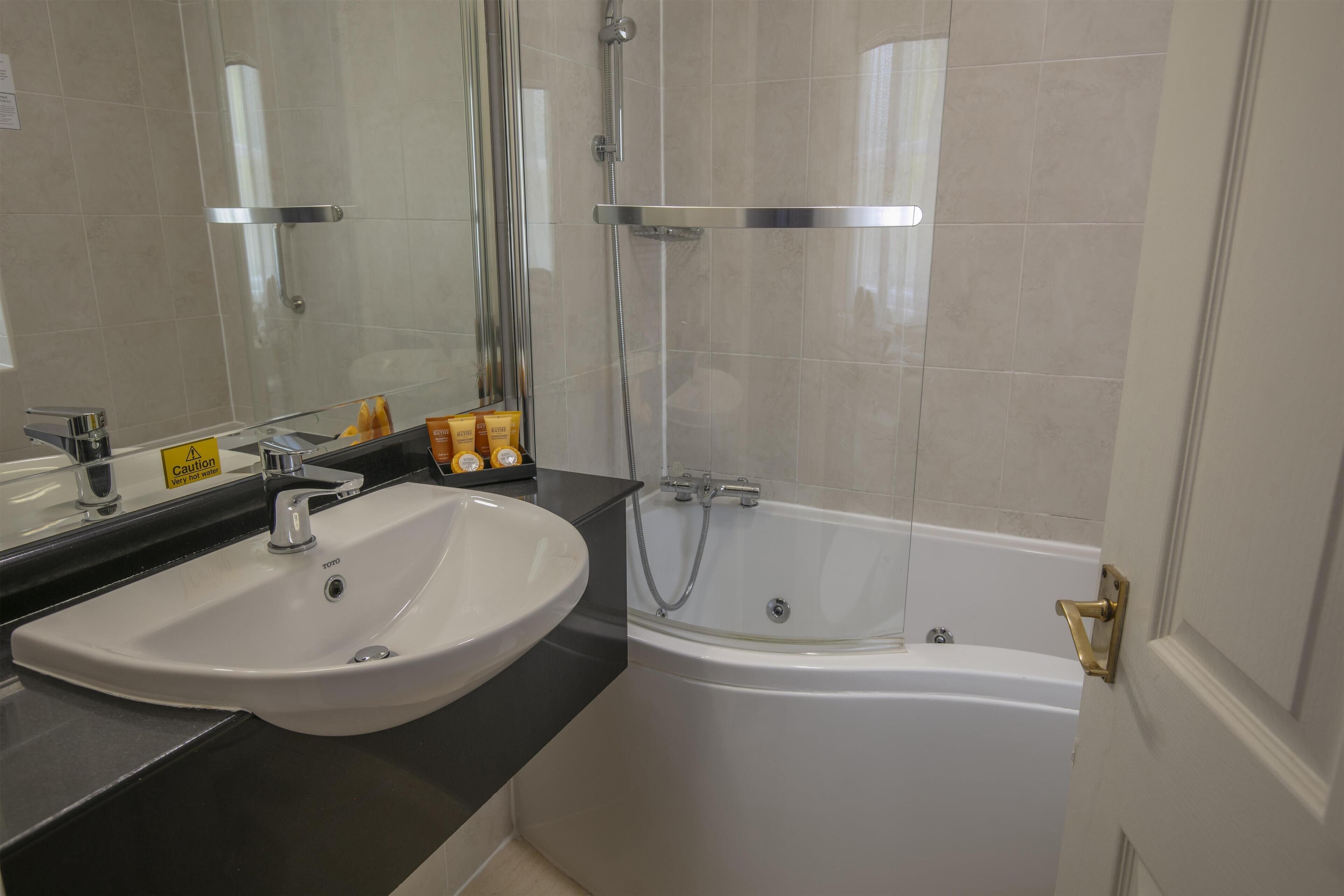 A bathroom with a white sink, a bathtub, and a shower.