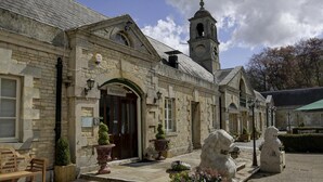 A stone building with a reception area, a bell tower, and stone lion statues. - Normanton Park Hotel, BW Signature Collection (Oakham)
