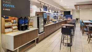 A modern cafe with a coffee station, yogurt and egg dispensers, and seating areas.