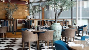 A restaurant with a checkered floor, wooden furniture, and large windows.