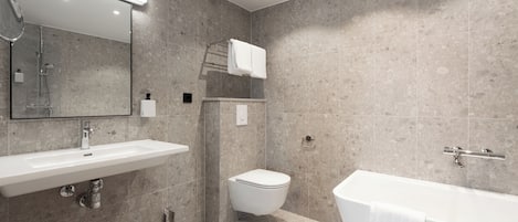 Un baño moderno con un lavamanos grande, inodoro y bañera.