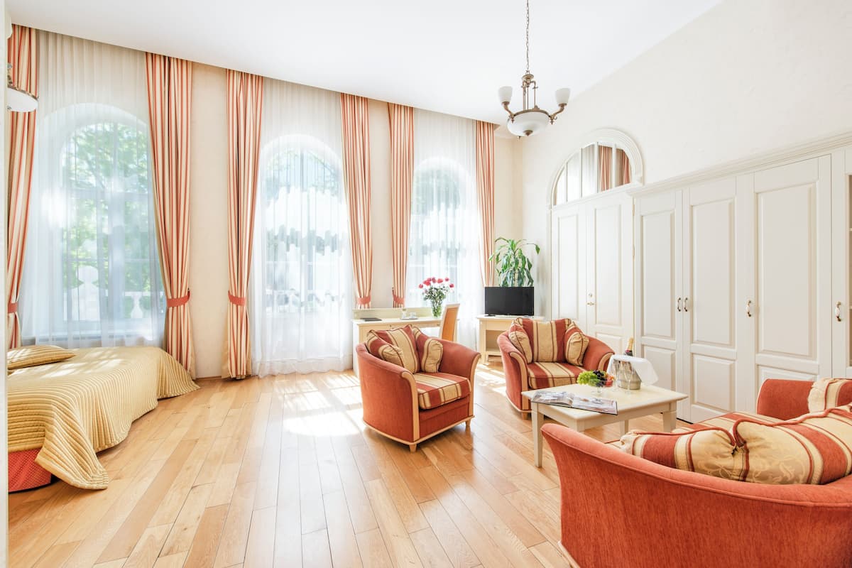 Un salon spacieux comprenant un grand lit, deux canapés, une table basse et un téléviseur.