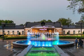 Ein Hotel mit Springbrunnen, einer Loungebar und einem gepflegten Garten.
