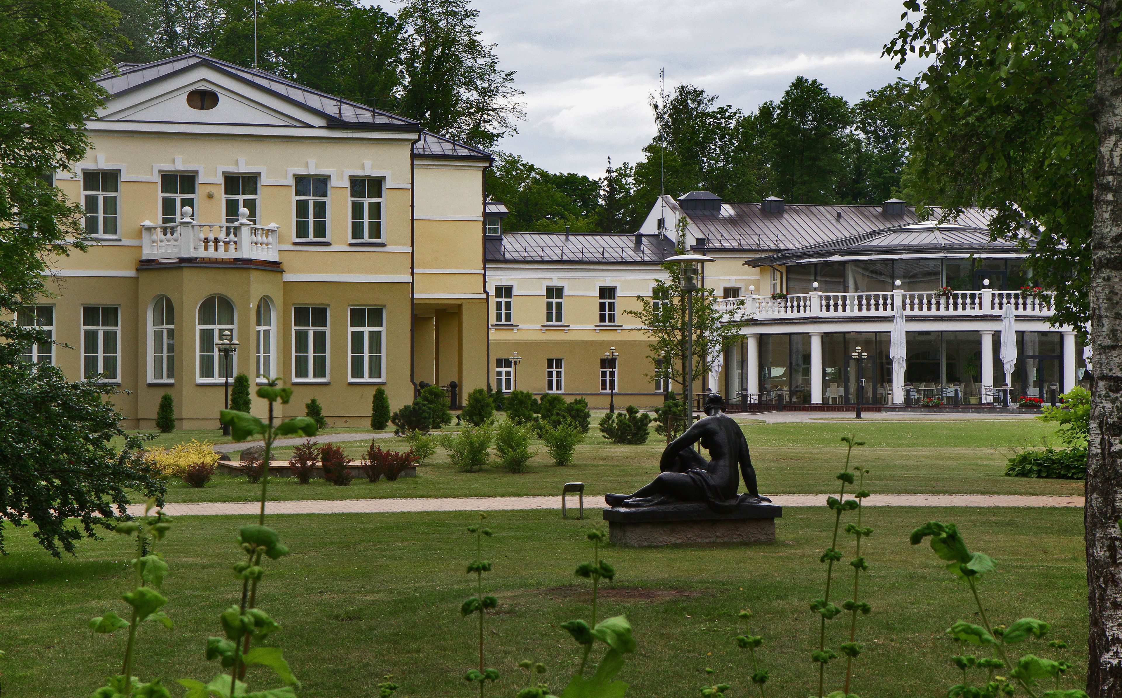 Ein stattliches Gebäude mit einer symmetrischen Fassade, großen Fenstern und einem Balkon.