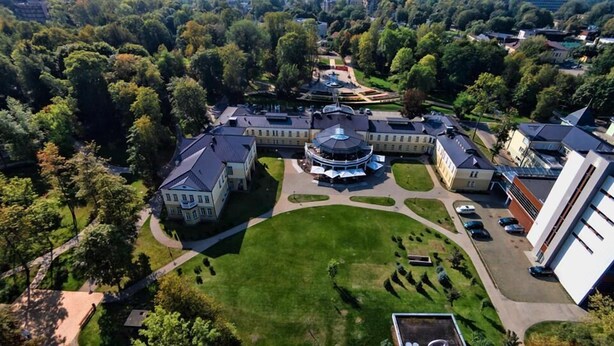An aerial view of a campus with multiple buildings, a central circular structure, and well-maintained lawns. - Spa Hotel Europa Royale Druskininkai (Druskininkai)