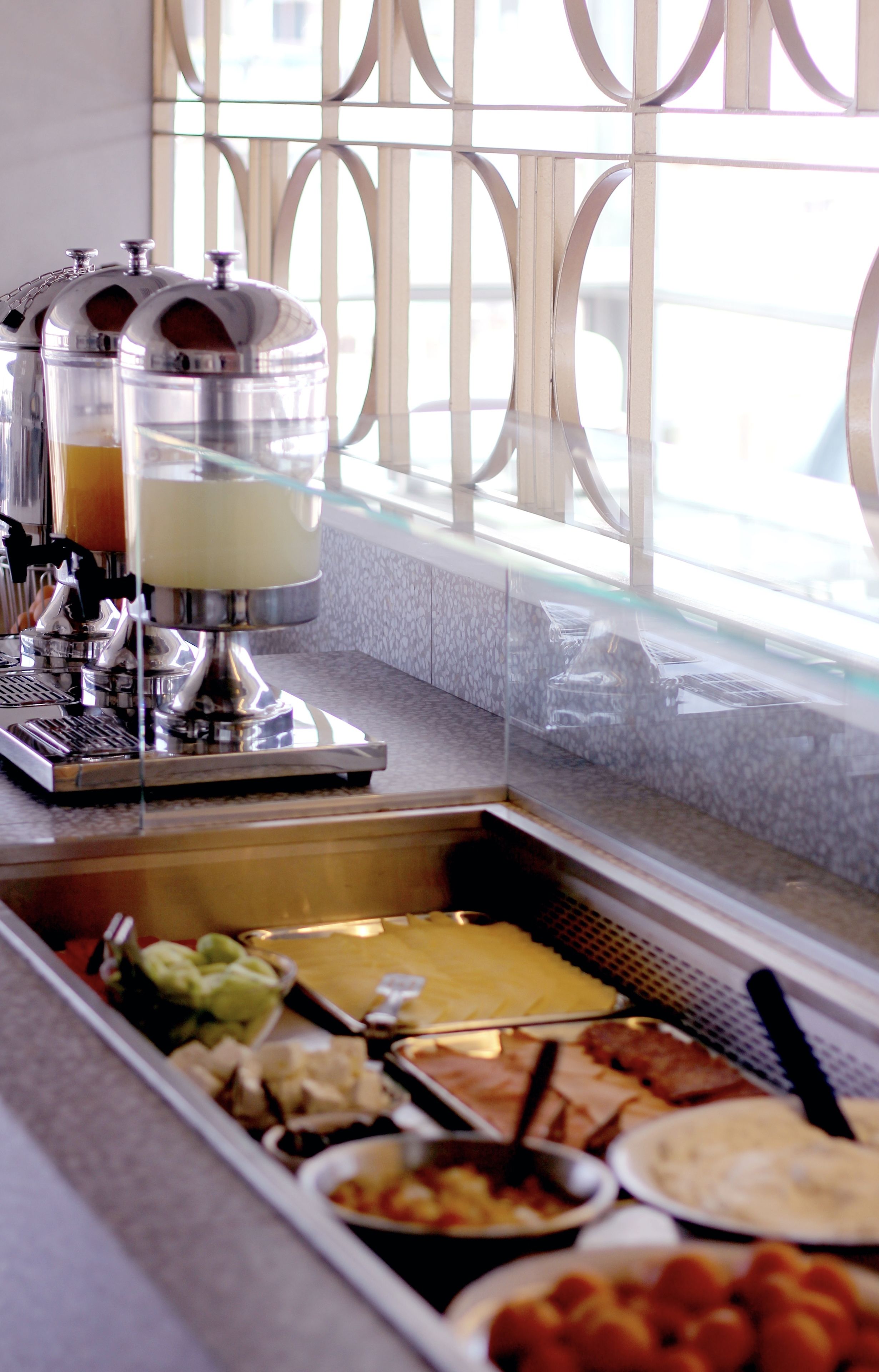 Montaje de bufé con diferentes opciones de comida y una máquina de café.